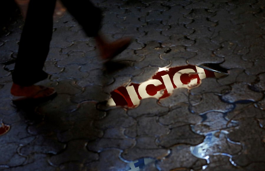 <div class="paragraphs"><p> ICICI signboard is reflected in a puddle.</p></div>
