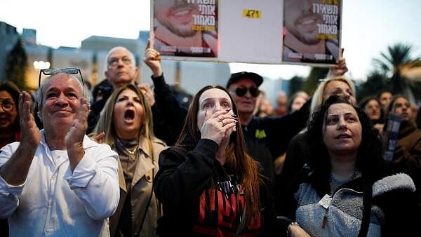 <div class="paragraphs"><p>People react as they watch news coverage of the release of Romi Gonen, Doron Steinbrecher and Emily Damari, three female hostages who have been held in Gaza since the deadly October 7 2023 attack, as part of a ceasefire deal in Gaza between Hamas and Israel, in Tel Aviv, January 19, 2025.</p></div>