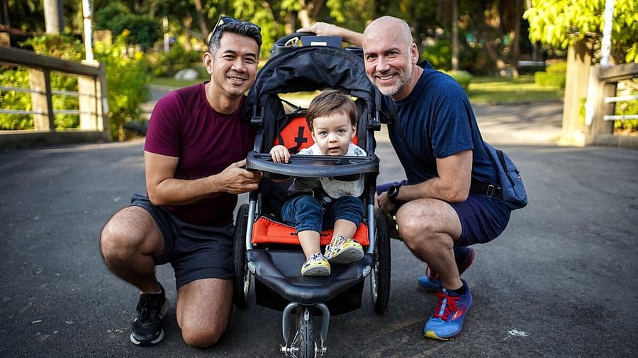 <div class="paragraphs"><p>A gay couple, Surapong "Keng" Koonpaew, 48, and Jacob Holder, 45, pose for photo with their son, Elijah Bprin Holder Koonpaew, at a park in Bangkok, Thailand, January 11, 2025.</p></div>