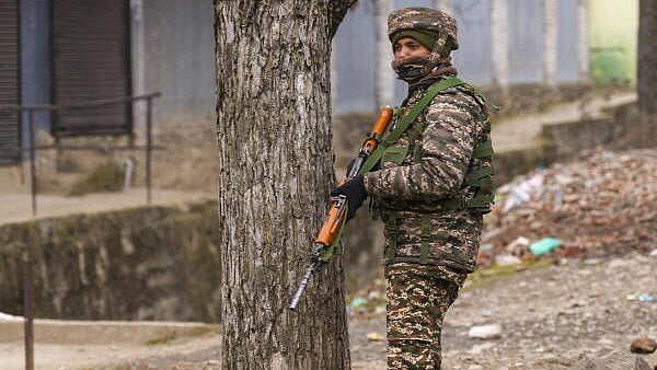 <div class="paragraphs"><p>A security personnel stands guard near the site of the encounter, at Gujjarpati area in Sopore, Baramulla district of Jammu and Kashmir, on Monday.</p></div>