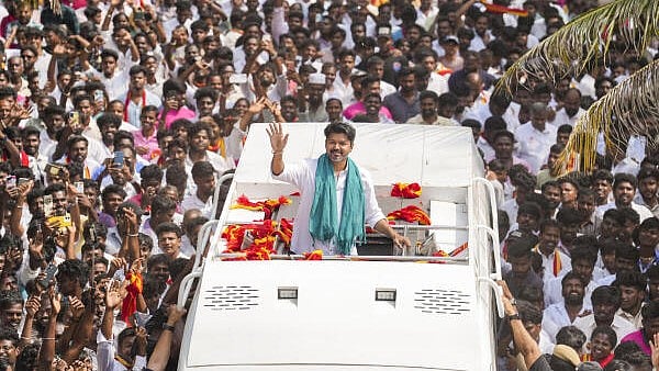 <div class="paragraphs"><p>TVK chief and actor Vijay waves as he meets with villagers of Ekanapuram who have been opposing the proposal to establish a greenfield airport at Parandur, in Kanchipuram district, on Monday.</p></div>