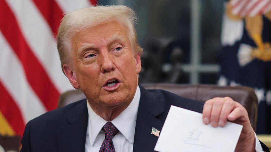 <div class="paragraphs"><p>US President Donald Trump holds up letter from former President Joe Biden while signing executive orders in the Oval Office at the White House on inauguration day.</p></div>