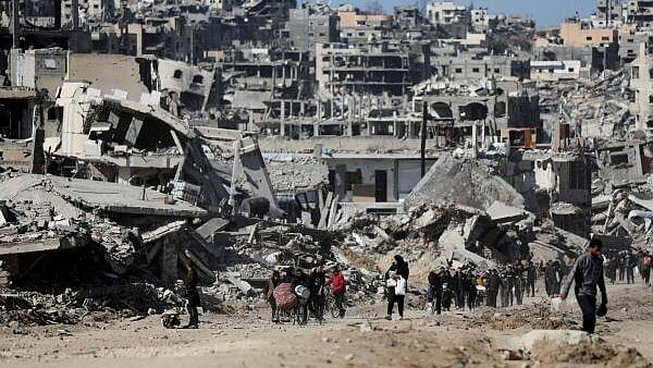 <div class="paragraphs"><p>Palestinians make their way past the rubble of destroyed houses and buildings, following a ceasefire between Israel and Hamas, in Jabalia in the northern Gaza Strip, January 21, 2025.</p></div>