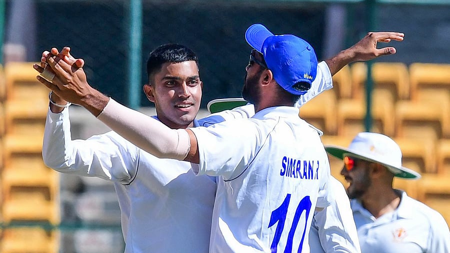 <div class="paragraphs"><p>Yashovardhan Parantap (left) of Karnataka celebrates with team-mate R Smaran after dismissing a Punjab batter during their Ranji Trophy match at the M Chinnaswamy Stadium in Bengaluru on Saturday.</p></div>
