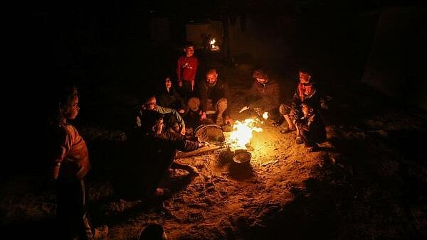 <div class="paragraphs"><p>Palestinians, displaced by Israel’s orders to southern Gaza during the war, light a fire next to their tent as they wait to be allowed to return to their homes in northern Gaza, amidst the ceasefire between Israel and Hamas, in Deir al-Balah in central Gaza Strip, January 25, 2025.</p></div>