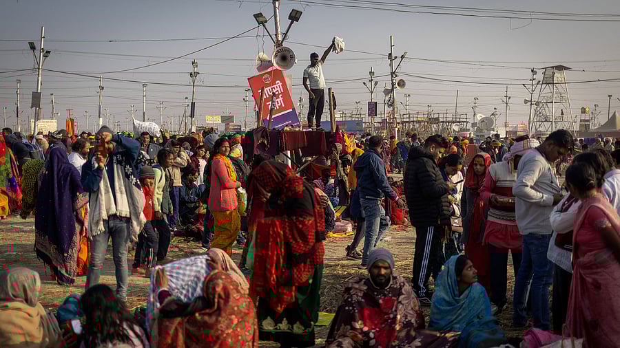 <div class="paragraphs"><p>A Hindu devotee stands on top of a police check-post waving as he looks for his family members after taking a holy dip at Sangam during the Maha Kumbh Mela</p></div>