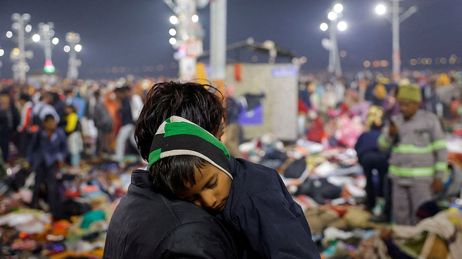 <div class="paragraphs"><p>A Hindu devotee holds his son as they leave after a deadly stampede before the second "Shahi Snan" at the "Maha Kumbh Mela"</p></div>