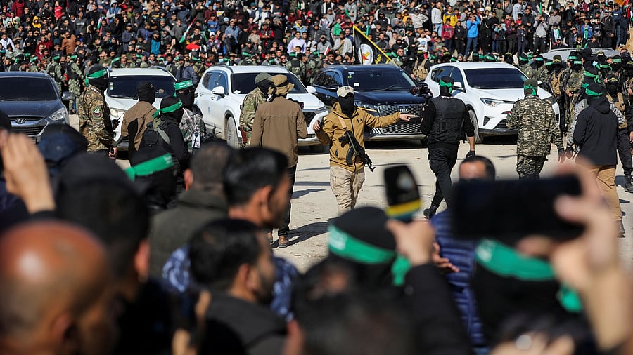 <div class="paragraphs"><p>Palestinians gather as Hamas and Islamic Jihad militants keep guard on the day of the release of four female Israeli soldiers</p></div>