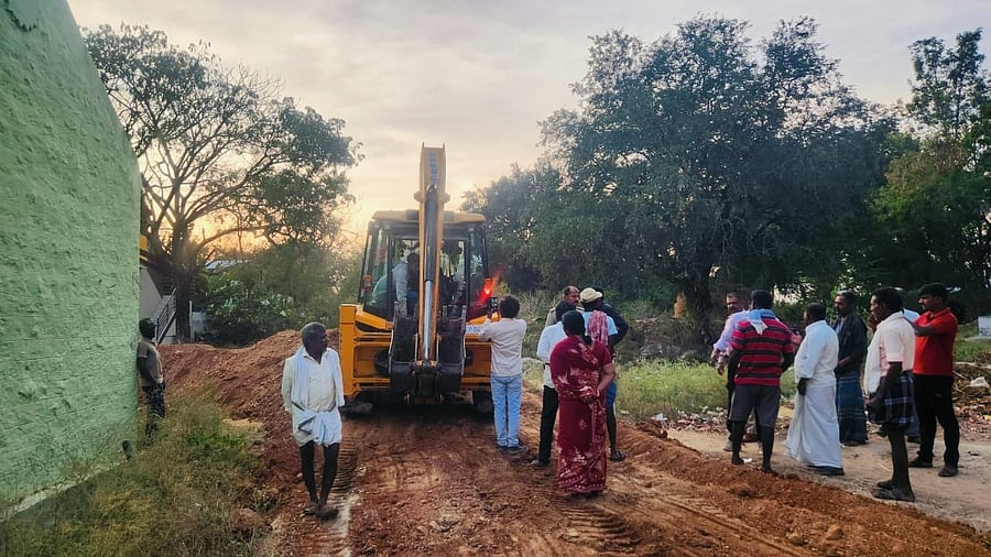 <div class="paragraphs"><p>Villagers stage a protest in front of an excavator, at a playground in Hadagalu village on Friday.</p></div>