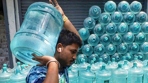 <div class="paragraphs"><p>A man carries a drinking water can after buying it from a store.</p></div>