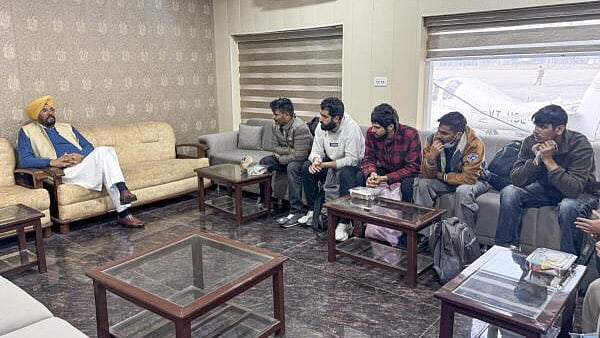 <div class="paragraphs"><p>Punjab NRI Affairs Minister Kuldeep Singh Dhaliwal, left, interacts with illegal Indian immigrants, who were deported from the US, upon their arrival, in Amritsar, on Wednesday.</p></div>