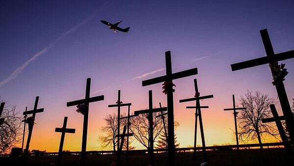 <div class="paragraphs"><p>A plane flies over crosses near the Ronald Reagan Washington National Airport, in the aftermath of the collision of American Eagle flight 5342 and the helicopter that crashed into the Potomac River, in Arlington, Virginia, US.</p></div>