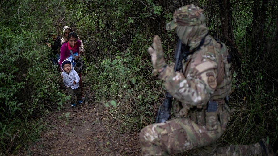 <div class="paragraphs"><p>A Border Patrol official waves towards a family that illegally crossed into the the US from Mexico in Fronton, Texas.</p></div>
