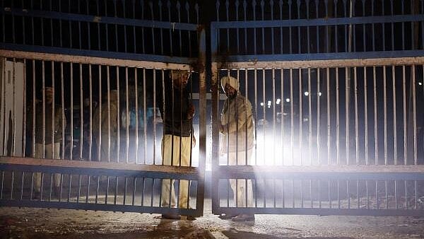 <div class="paragraphs"><p>Policemen stand guard at the gate as police vehicles transporting Indian immigrants deported from the US leave the airport in Amritsar.</p></div>