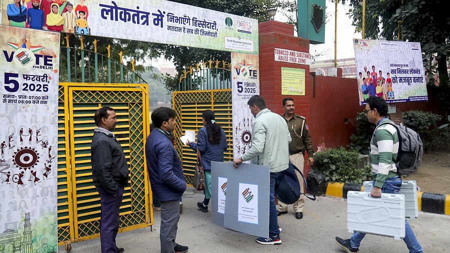 <div class="paragraphs"><p>Polling officials carrying EVMs and other election materials arrive at a polling centre at Gole Market ahead of Delhi Assembly poll, in New Delhi.</p></div>