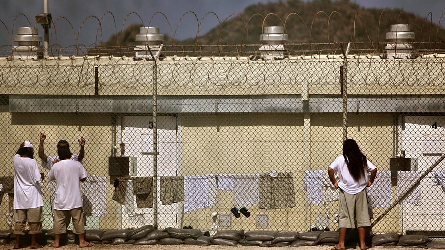 <div class="paragraphs"><p>Detainees talk together inside the open-air yard at the Camp 4 detention facility at Guantanamo Bay</p></div>