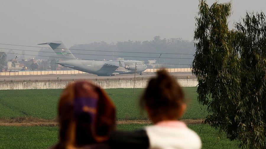 <div class="paragraphs"><p>A woman and child watch the US plane carrying Indian deportees land in Amritsar</p></div>