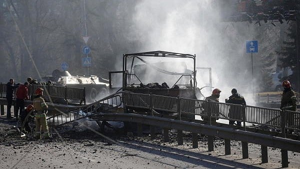 <div class="paragraphs"><p>Ukrainian servicemen and first responders stand by a damaged vehicle, at the site of fighting with Russian troops, after Russia launched a massive military operation against Ukraine, in Kyiv</p></div>