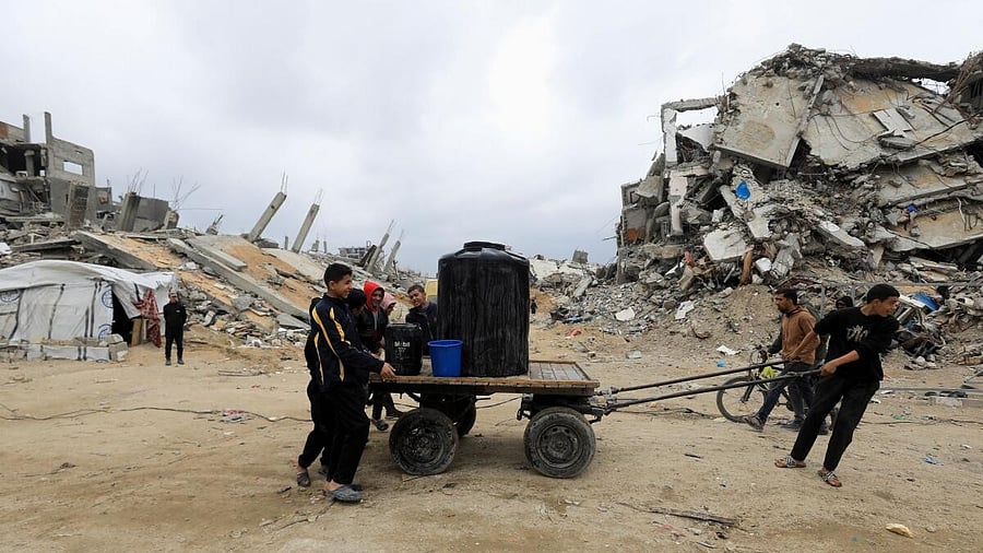<div class="paragraphs"><p>Palestinians push a cart with water tank in Jabalia refugee camp</p></div>