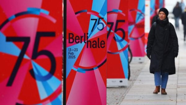 <div class="paragraphs"><p>A pedestrian walks past advertising posters for the upcoming 75th Berlinale International Film Festival in Berlin, Germany.</p></div>