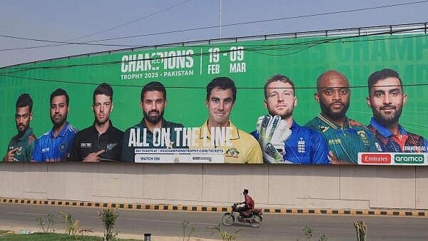 <div class="paragraphs"><p>A person rides on a motorbike past a wall with a billboard advertisment ahead of the ICC Champions Trophy 2025 tournament, in Karachi</p></div>
