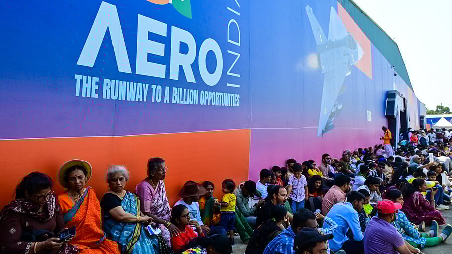 <div class="paragraphs"><p>Visitors sit near exhibition halls for watching the air show during the last day of Aero India at Yelahanka Air Force Station in Bengaluru on Friday. </p></div>