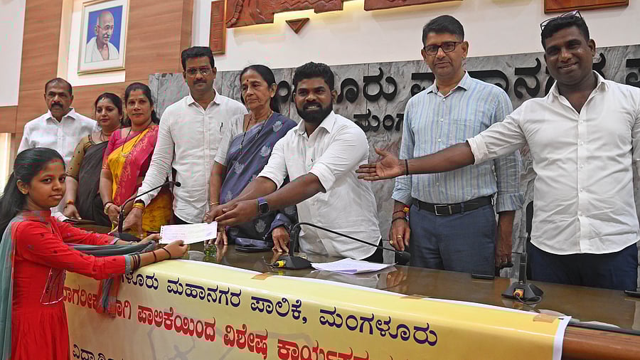 <div class="paragraphs"><p>Mayor Manoj Kumar hands over cheque to Shravya who has secured 92% in SSLC examination in Kannada medium, at the council hall in Mangaluru on Saturday.</p></div>
