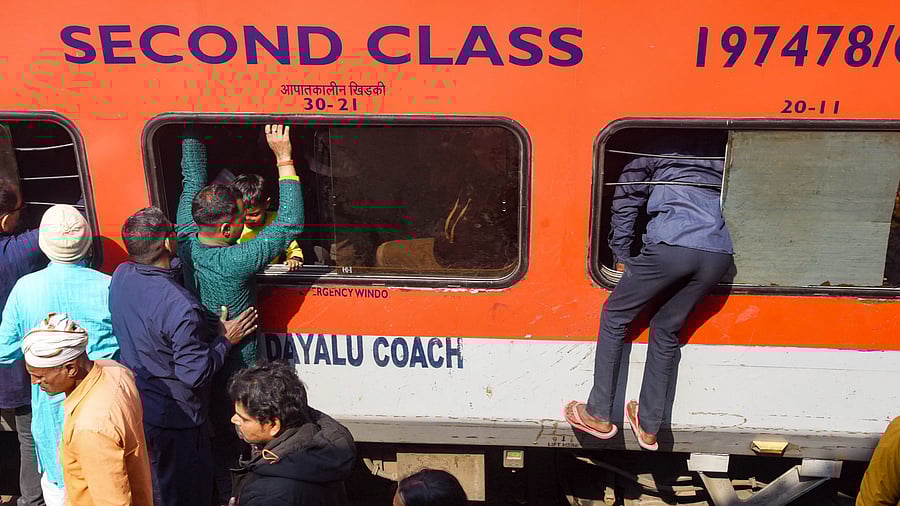 <div class="paragraphs"><p>Passengers try to board an overcrowded train through a window amid a huge rush owing to ongoing Prayagraj's Mahakumbh Mela, at the Patna Railway Station, Monday, Feb. 17, 2025.</p></div>
