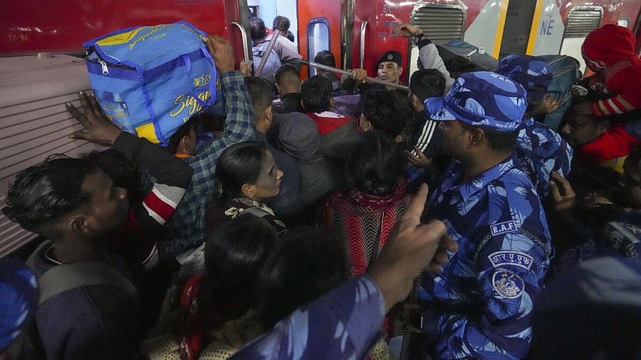 <div class="paragraphs"><p>Security personnel assist passengers boarding a train at the New Delhi Railway Station, in New Delhi, Sunday, Feb. 16, 2025. At least 18 people were killed and more than a dozen injured in a stampede that broke out late Saturday night at the crowded railway station in the national capital.</p></div>