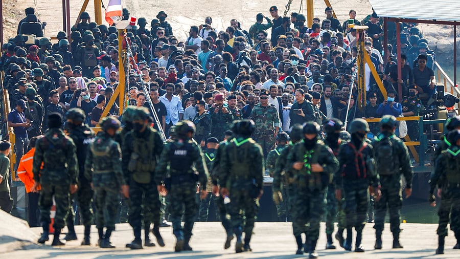 <div class="paragraphs"><p>Multinational victims of scam centers, who were tricked or trafficked into working in Myanmar, stand on a vessel floating towards the Thai side of border via Moei River in Phop Phra District, Tak province, Thailand February 12, 2025.</p></div>