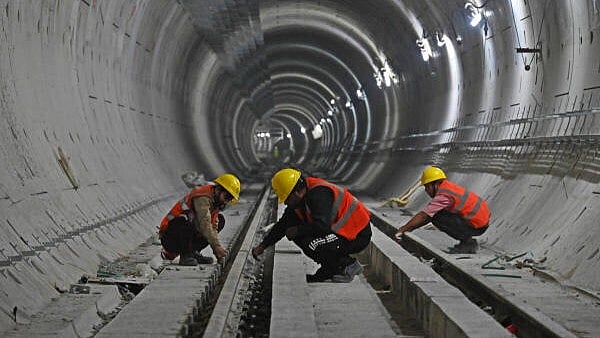 <div class="paragraphs"><p>Workers at the ongoing metro construction site at MG Road underground station connecting Shivajinagar and Vellara Stations on Bengaluru's Pink Line on Monday.</p></div>