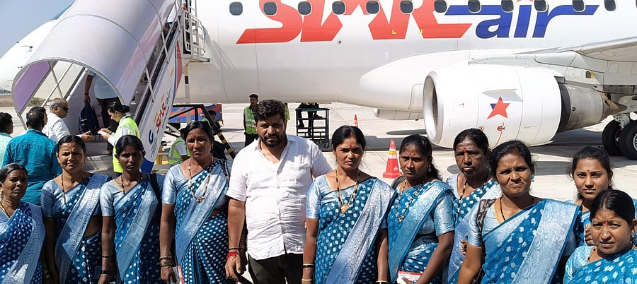 <div class="paragraphs"><p>Vishwanath, a farmer from Shiraganahalli village in Harapanahalli taluk of Vijayanagara district, poses with women workers from his farm, before boarding the flight to Goa from Shivamogga on Tuesday. </p></div>