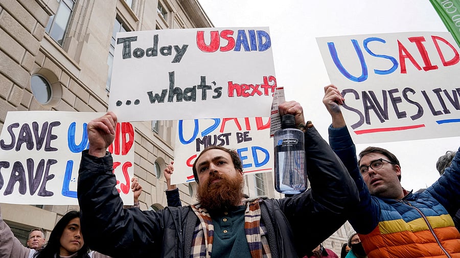 <div class="paragraphs"><p>People hold placards outside the USAID building</p></div>