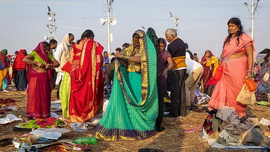 <div class="paragraphs"><p>Devotees change their clothes after taking a holy dip at Sangam, the confluence of the Ganges and Yamuna rivers with the mythical, invisible Saraswati river, during the Maha Kumbh Mela.</p></div>