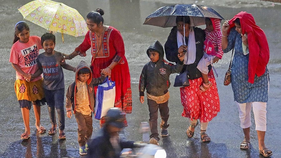 <div class="paragraphs"><p>People cross a road amid rains, in Bengaluru, Karnataka.</p></div>