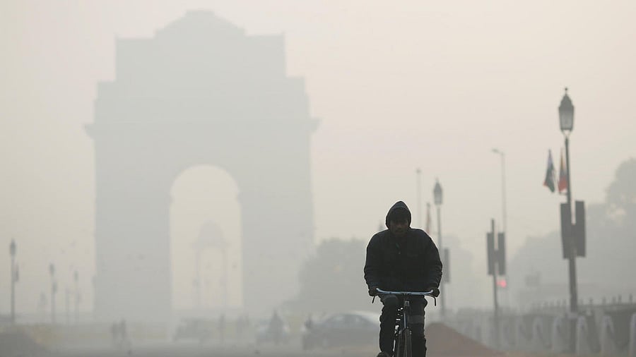 <div class="paragraphs"><p>A man rides his bicycle in front of the India Gate shrouded in smog in New Delhi</p></div>