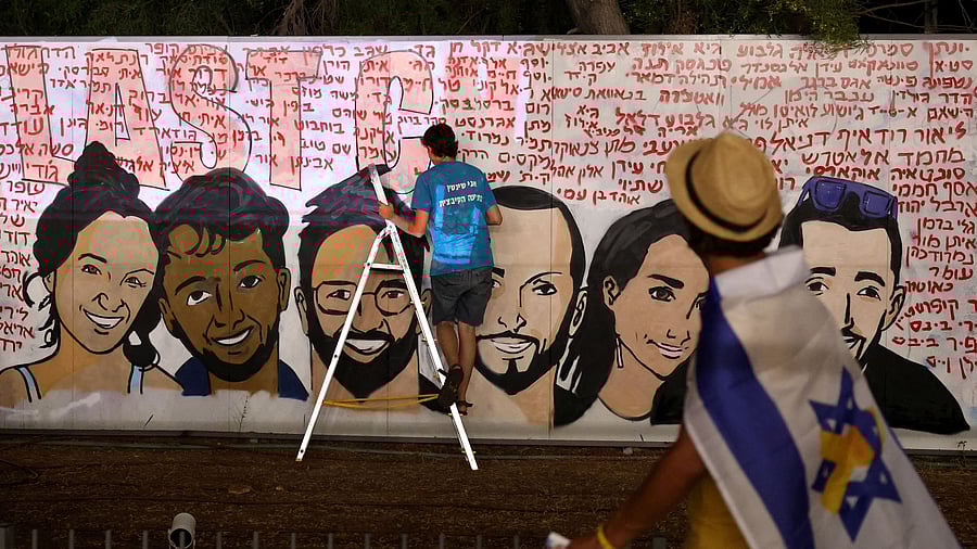 <div class="paragraphs"><p>An Israeli artist works on a graffiti art work depicting the six Israeli hostages who were kidnapped by Hamas during the October 7 attacks, and whose bodies have been found underground after they were killed in the Rafah area of the Gaza Strip and returned to Israel, amid the Israel-Hamas conflict, in Tel Aviv, Israel, September 8, 2024. The words in Hebrew around the portraits are all the names of hostages in Gaza. </p></div>