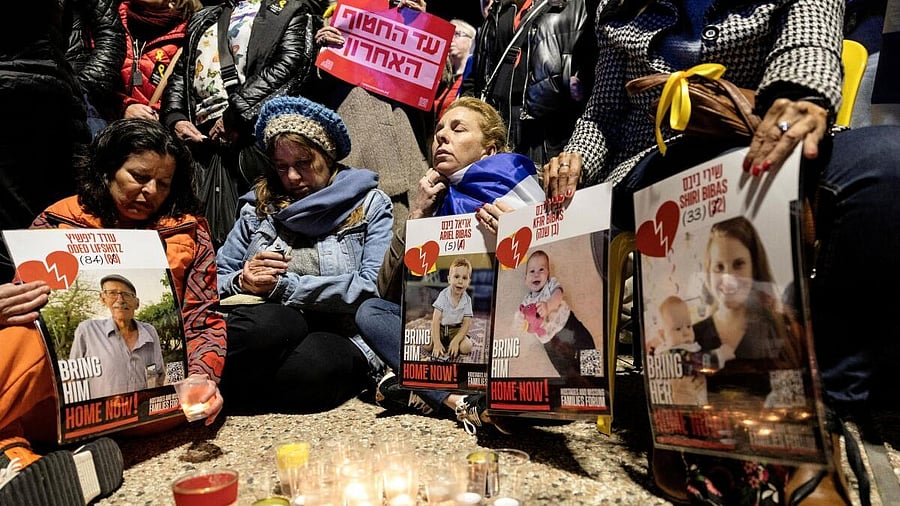 <div class="paragraphs"><p>Israelis sit together as they light candles and hold posters with the images Oded Lifschitz, Shiri Bibas and her two children, Kfir and Ariel Bibas, seized during the deadly October 7, 2023 attack by Hamas</p></div>