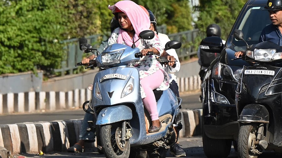 <div class="paragraphs"><p>A woman cover themselves with a cloth and riding a scooter during the scorching sun on a hot summer day in Bengaluru.</p></div>