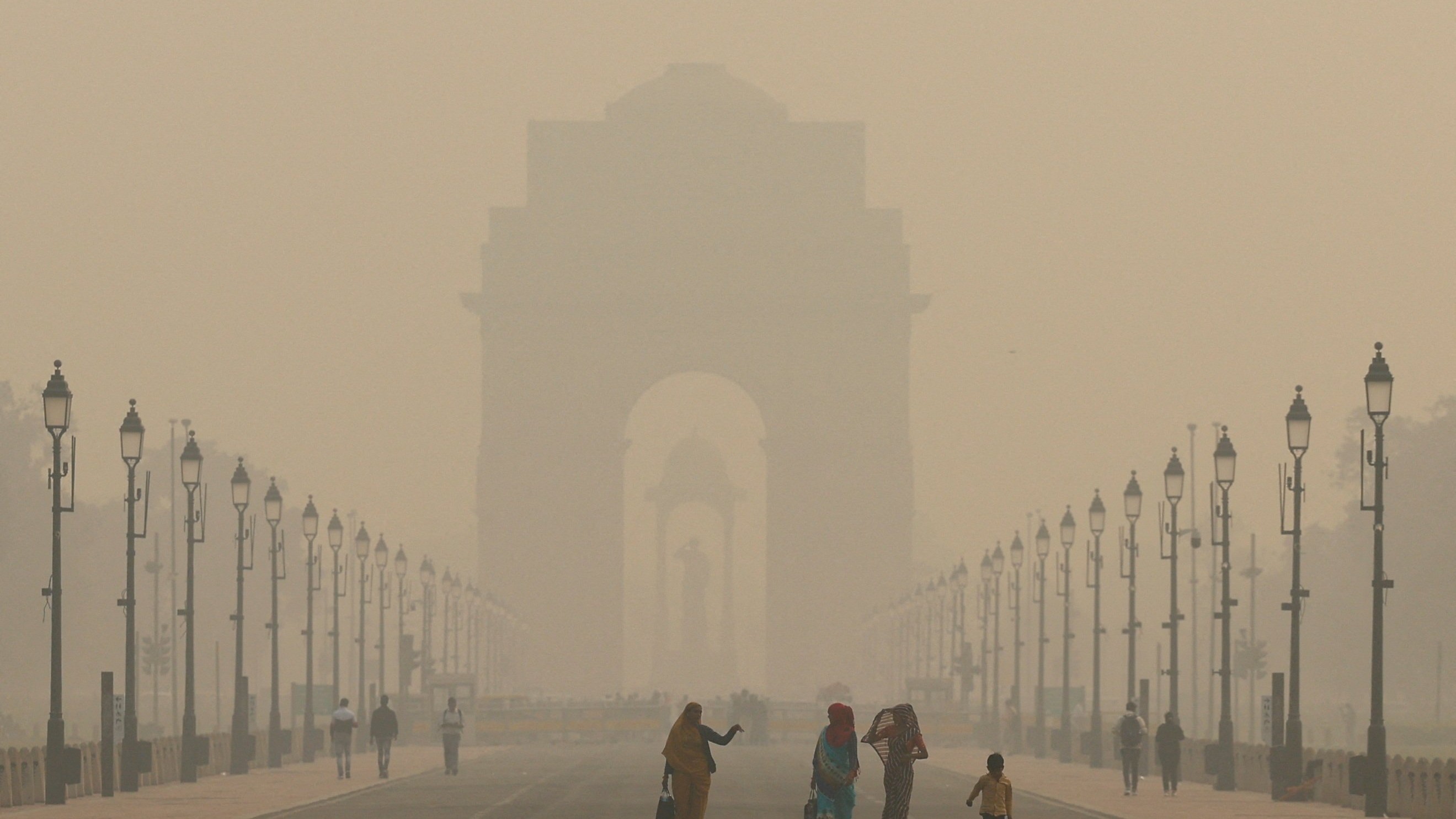 <div class="paragraphs"><p>Women walk on a road near India Gate as the sky is enveloped with smog </p></div>