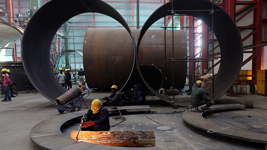 <div class="paragraphs"><p>A worker cuts a metal plate inside an industrial tank manufacturing factory</p></div>
