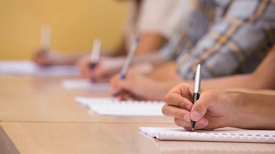 <div class="paragraphs"><p>A person writing in book </p></div>