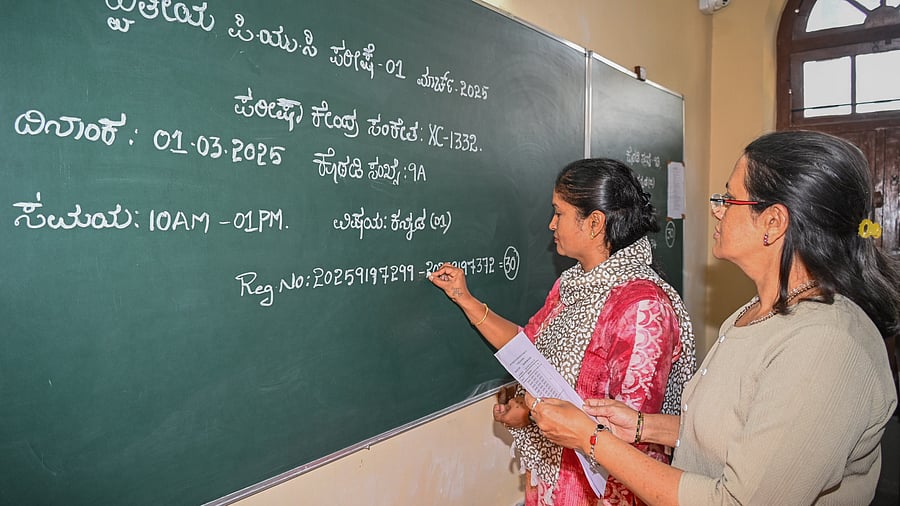 <div class="paragraphs"><p>Teachers write the roll numbers of students, who are appearing for the second PUC examinations, on a classroom board of the Government Girls’ Pre-University College at the Fort area in Bengaluru on Friday. </p></div>