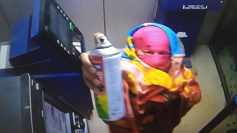 One of the suspects spraying paint on the CCTV camera.