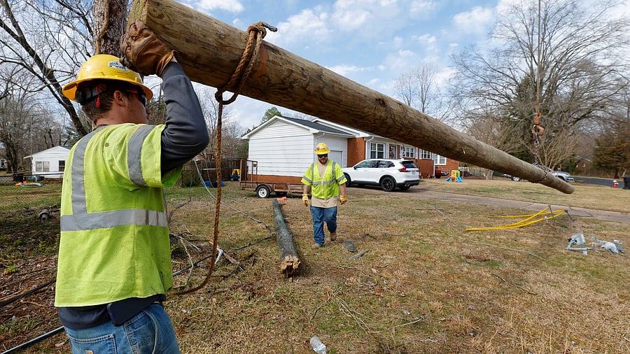 <div class="paragraphs"><p>A utility construction company worker guides a replacement power pole into position during repairs shortly after a severe storm with gale-force gusts swept through the southeastern part of the country, in Burlington, North Carolina US. </p></div>