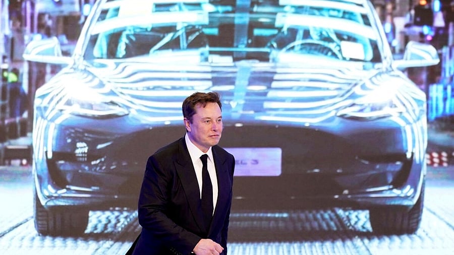 <div class="paragraphs"><p>Tesla Inc CEO Elon Musk walks next to a screen showing an image of Tesla Model 3 car.</p></div>