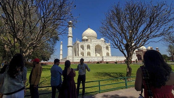 <div class="paragraphs"><p>Tourist at the Taj Mahal as the monument glows against a clear blue sky, in Agra.</p></div>