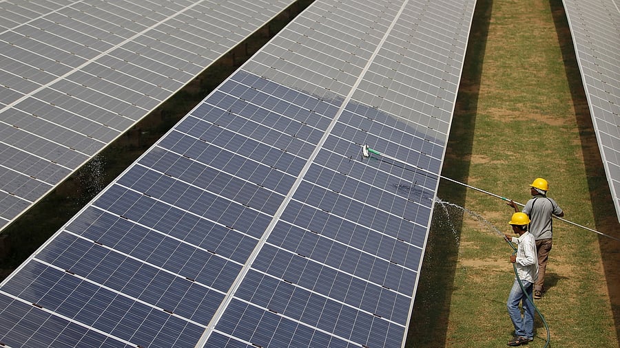 <div class="paragraphs"><p>FILE PHOTO: Workers clean photovoltaic panels inside a solar power plant in Gujarat, India.&nbsp;</p></div>