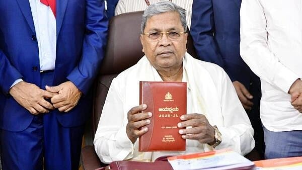 <div class="paragraphs"><p>Karnataka Chief Minister Siddaramaiah displays Budget documents, in Bengaluru, Friday, March 7, 2025.</p></div>