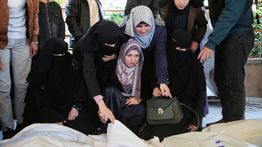 <div class="paragraphs"><p>Mourners react beside the bodies of Palestinians killed in Israeli airstrikes.</p></div>